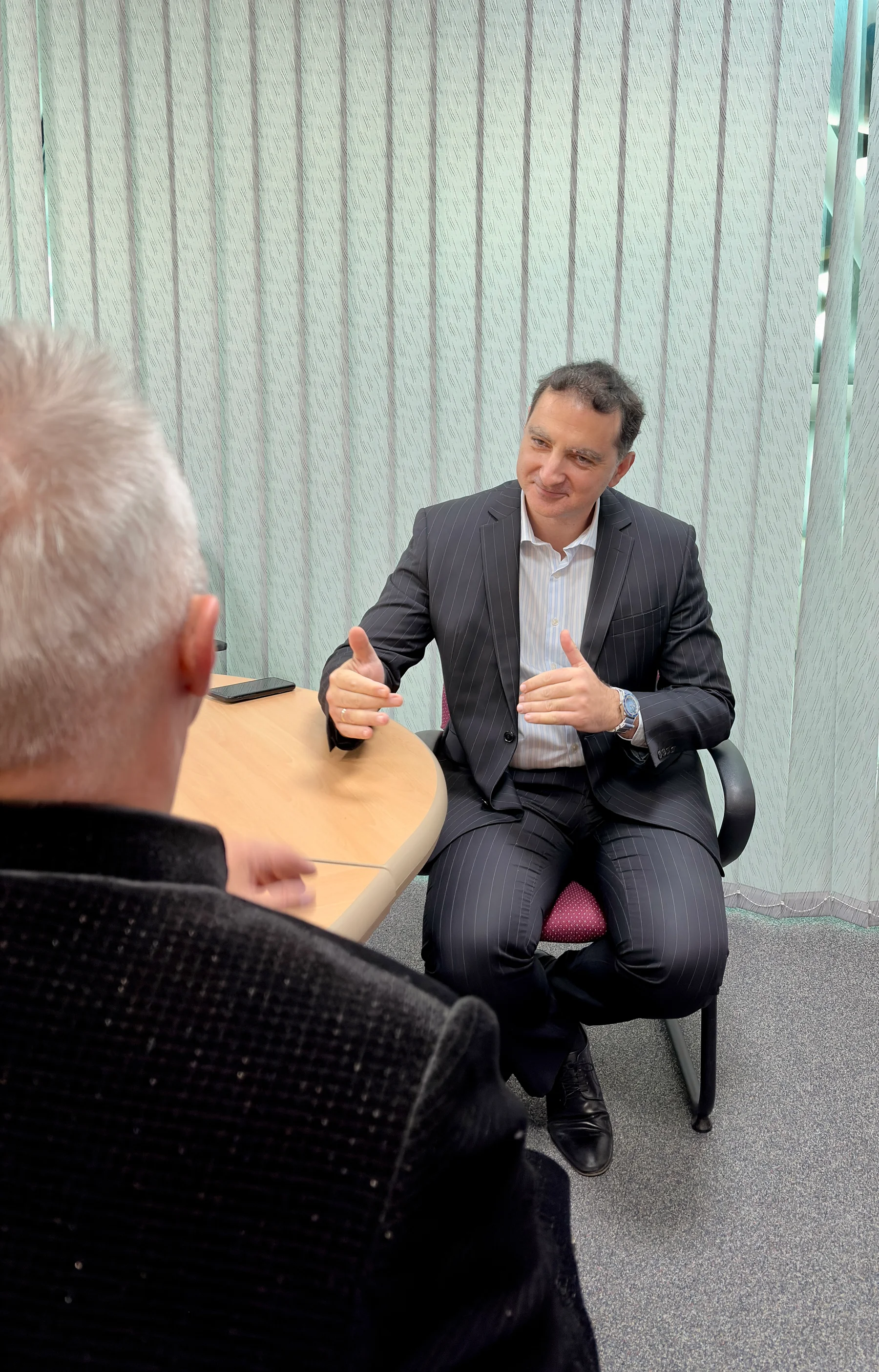 Jim Kandias in a focused conversation across an office table