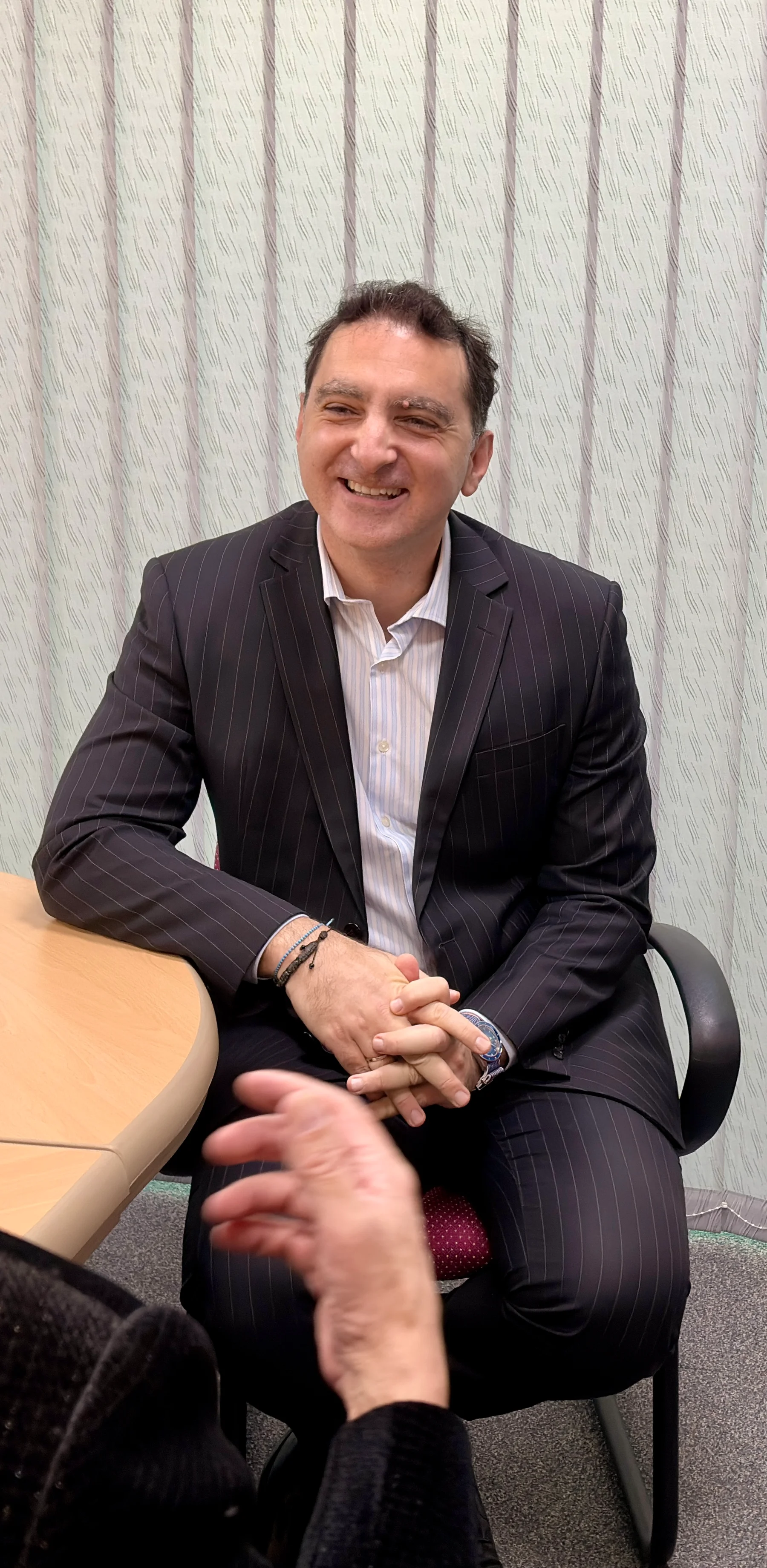Jim Kandias smiling and listening during an office conversation