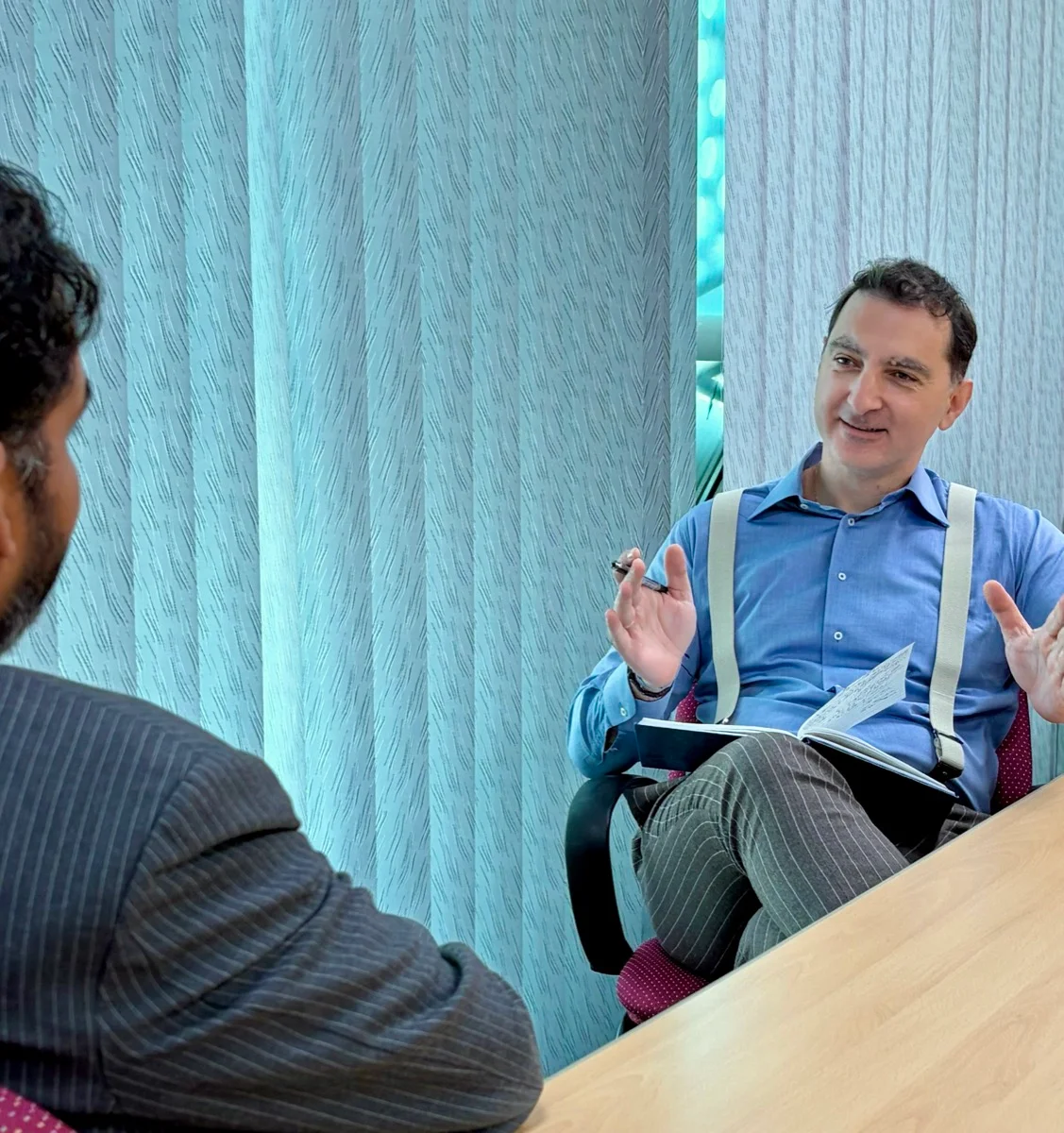 Jim Kandias discussing ideas with a notebook open in an office conversation